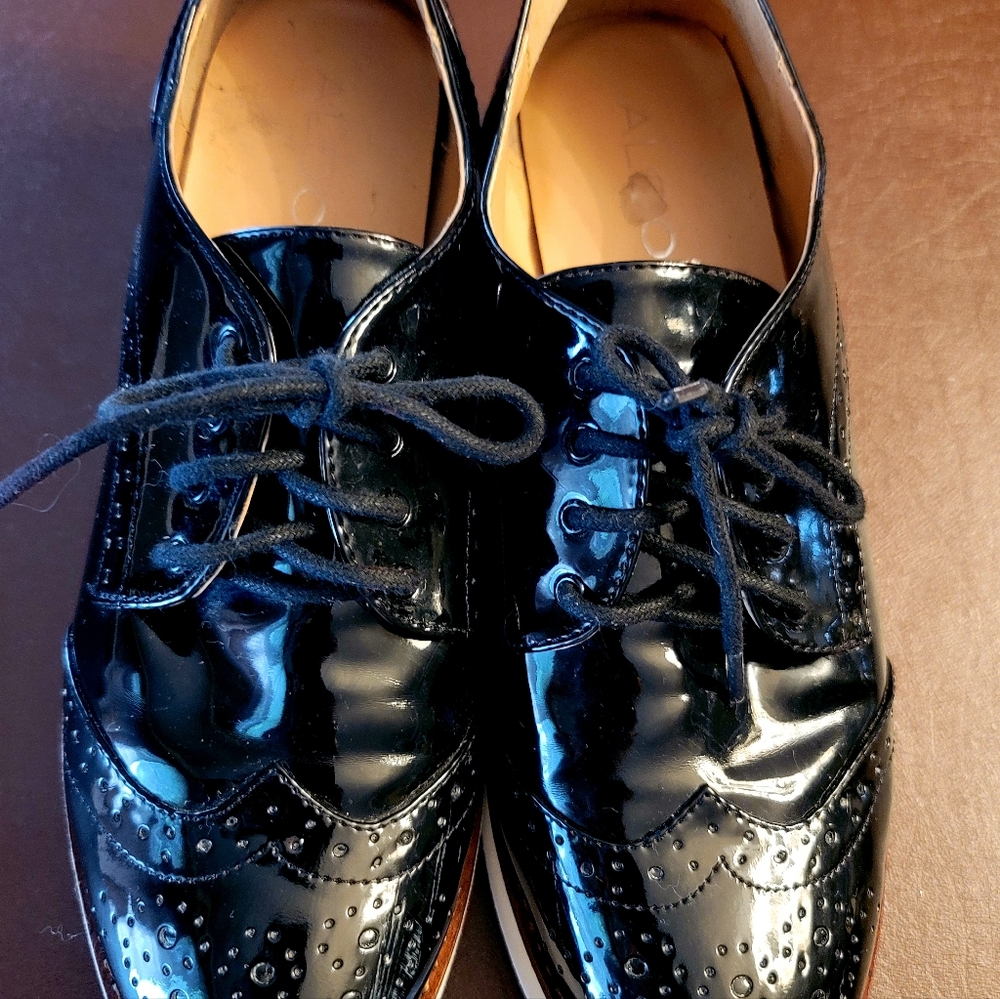 ALDO black patent leather Oxford shoes with white platform.